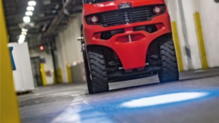 Un chariot frontal Fenwick avec BlueSpot projette un point d’avertissement bleu sur le sol