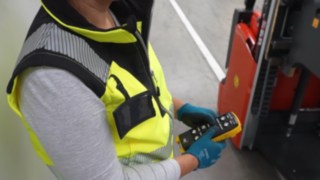 Une collaboratrice commande à distance le chariot élévateur antidéflagrant L03 EX de Fenwick
