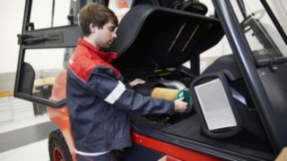 Collaborateur du service maintenance Linde près d'un chariot élévateur Collaborateur du service maintenance Linde près d'un chariot élévateur