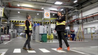 Limiter le risque de contamination au Covid-19 - la veste de distanciation Fenwick assure le respect de la bonne distance Deux collaborateurs portant la veste de distanciaton Fenwick se rencontrent à bonne distance