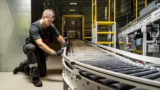 Un technicien de service de Fenwick répare un convoyeur à rouleaux