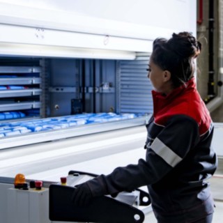 Une technicienne de service de Fenwick s’occupe du système de stockage automatisé pour petites pièces.