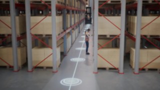 Animation d’une employée portant un gilet de protection dans un entrepôt à allées étroites et de zones de sécurité pour la détection des personnes