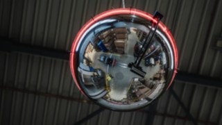 Un miroir rond avec une bande lumineuse qui s’allume en rouge pour indiquer qu’un chariot élévateur s’approche. Un miroir rond avec une bande lumineuse qui s’allume en rouge pour indiquer qu’un chariot élévateur s’approche.