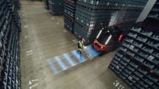 Le radar anticollision est actif Un piéton marche derrière le Fenwick X30.