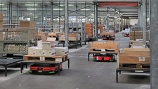 Les chariots à plateforme automatisés C-MATIC de Fenwick transportent des caisses et des palettes à travers l’entrepôt d’ABS Safety,