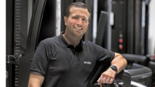 Tibor Sevenheck s’appuie sur un VNA et sourit à la caméra.