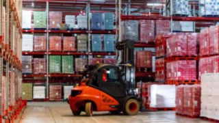 Un chariot élévateur Fenwick saisit une palette de caisses de boissons dans l’usine française de Coca-Cola European Partners France.