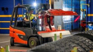 Un employé de Michelin Tyre PLC saisit une pile de pneus avec une pince à pneus sur le Fenwick E20.