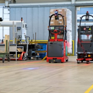 Deux chariots élévateurs automatiques L-MATIC acheminent les marchandises entre la ligne d’emballage et l’entrepôt à flux continu.