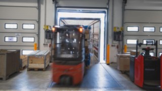 Un chariot électrique Fenwick charge un camion par la rampe de chargement