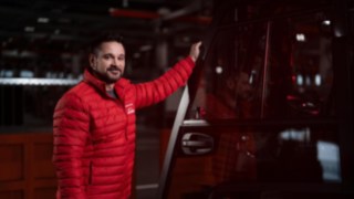 Un collaborateur Linde Material Handling se tient à côté d’un chariot élévateur et sourit à la caméra.