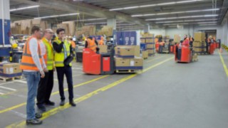 Trois personnes analysent les particularités d’un atelier d’usine.