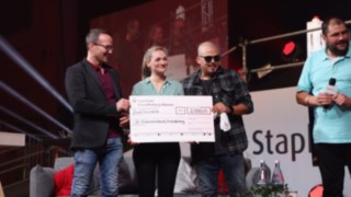 L’association StaplerCup hilft e. V. s’occupe de l’intégration d’enfants défavorisés dans les régions d’Aschaffenbourg, Alzenau et Miltenberg. Deux hommes et une femme tiennent un chèque de don lors de la StaplerCup