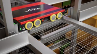 Les navettes du S-MATIC cube peuvent passer facilement sous les palettes et ainsi se déplacer rapidement dans l’entrepôt. Une navette dans une allée