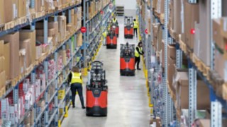 Un préparateur de commandes de la nouvelle série N20 de Fenwick-Linde dans un entrepôt Employés travaillant dans un entrepôt avec les préparateurs de commandes de la nouvelle série N20